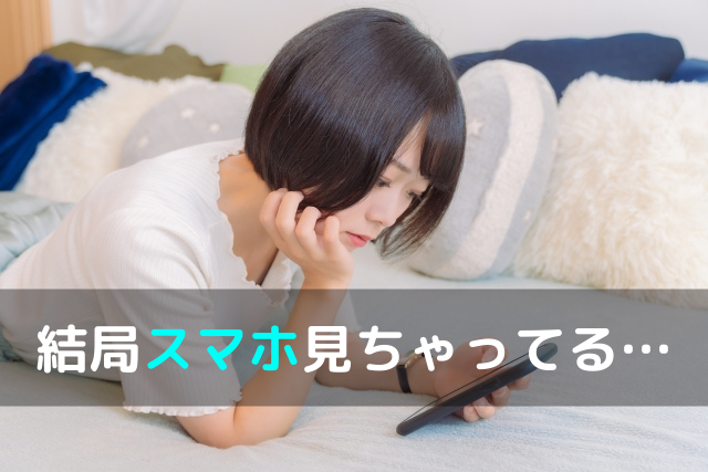 ベッドでスマホを見る女性